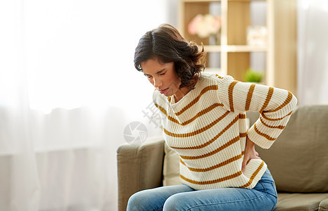 人,医疗保健问题快乐的女人家里遭受背部的疼痛幸的女人家里背痛图片