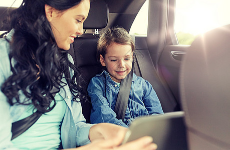 家庭,交通,公路旅行,旅行人的快乐的女人小女儿与平板电脑电脑汽车上驾驶快乐的家庭与平板电脑驾驶汽车图片