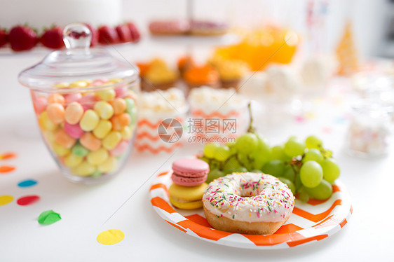 食物节日葡萄,马卡龙甜甜圈聚会桌上聚会桌上的葡萄马卡龙甜甜圈图片