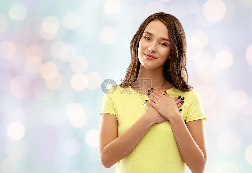 欣赏,情人节真诚的情感高兴的轻妇女十几岁的女孩穿着黄色T恤,手牵着手节日的灯光背景下微笑的十几岁女孩牵着手心图片