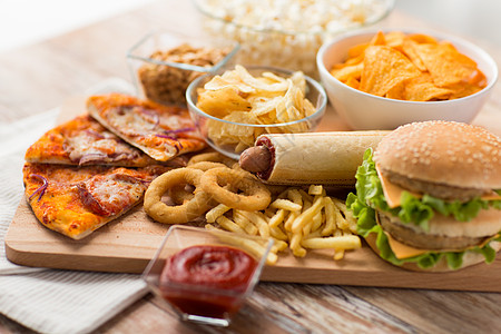 快餐健康的饮食双汉堡奶酪汉堡,油炸鱿鱼圈,炸薯条,比萨饼克里斯普木板上木板上快餐图片