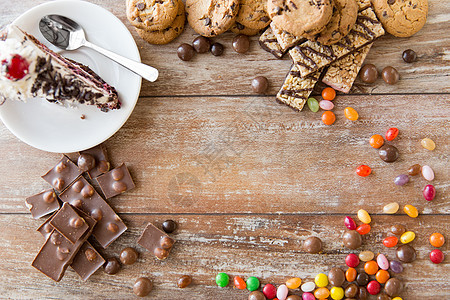 垃圾食品糖果健康的饮食观念把巧克力糖果块蛋糕饼干放木桌上桌子上同的糖果图片