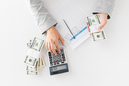 商业财务女商人与税务表格计算器计数美元的办公桌上手计算器税单数钱图片