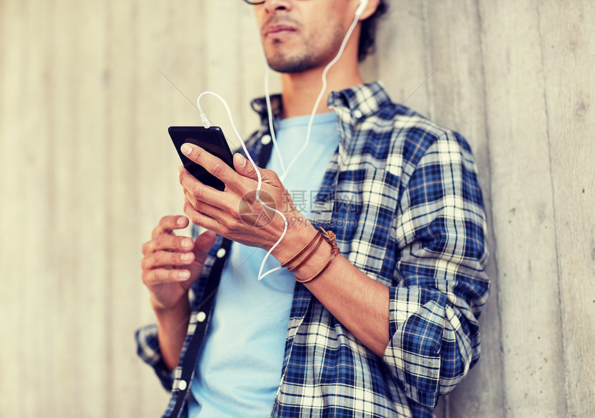 人,技术生活方式近距离的轻时尚男子与耳机智能手机听音乐带耳机智能手机听音乐的男人图片