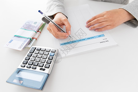 商业财务女商人与税务表格,计算器钱办公室桌子上把税单计算器钱放桌子上背景图片