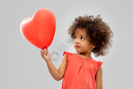 孩子气球童人的快乐的非裔美国女孩与红色心形气球灰色背景带心形气球的非裔美国女孩背景