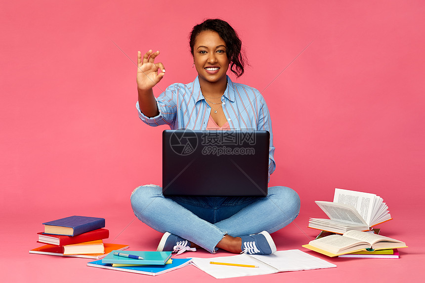 教育,高中技术快乐的非裔美国轻学生妇女,笔记本电脑书籍坐地板上,并粉红色的背景上OK手标志快乐的非裔美国图片