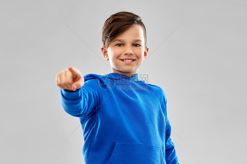 人的微笑男孩蓝色帽衫指指灰色背景微笑的男孩穿着蓝色帽衫指着手指
