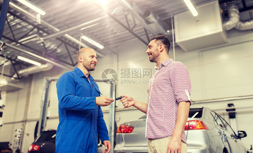 快乐的微笑的人车主汽车商店汽车修理工给汽车商店的人钥匙