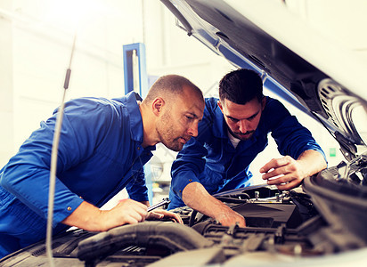 汽车服务,维修,维护人的技工与扳手修理汽车发动机车间车间用扳手修理汽车的机械工人图片