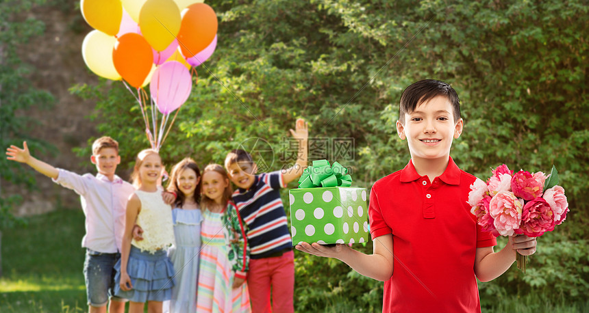 童人们的微笑的小男孩马球T恤与礼品盒鲜花生日聚会上的朋友夏季公园背景生日派上礼品盒鲜花的男孩图片