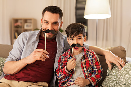 家庭,童父亲的快乐的父亲小儿子与芥末派道具家里玩得开心胡子的父子玩得开心图片
