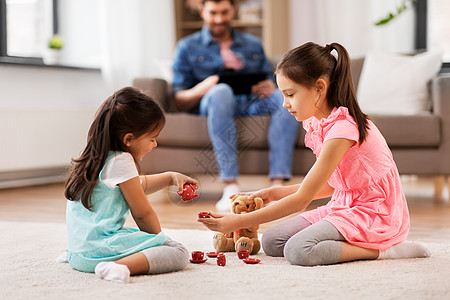 童休闲家庭观念小妹妹家里玩具陶器泰迪熊玩茶话会游戏女孩们家里玩玩具陶器泰迪图片