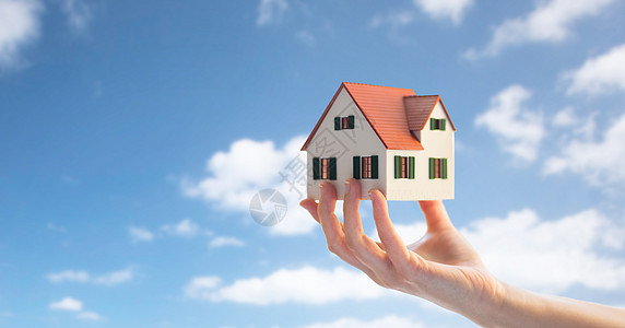 房地产,住宿财产近距离的手房子家庭模式蓝天云背景手房子家庭模型图片