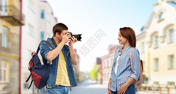 旅行,旅游度假的快乐的游客带着背包相机塔林市背景的老镇街上拍照带背包照相机的快乐游客背景图片