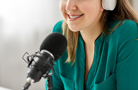 技术,大众媒体人的密切妇女与麦克风耳机交谈录音播客演播室演播室里麦克风录音播客的女人图片