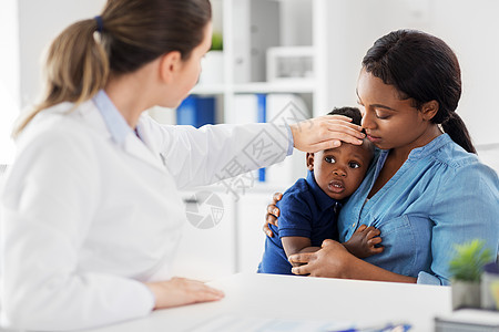 医学,医疗儿科非裔美国母亲与生病的儿子白种人医生测量婴儿的温度诊所手工测量母亲带着生病的孩子医生诊所图片