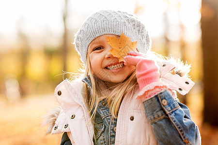 童,季节人的快乐的小女孩与枫叶秋天的公园秋天公园里带着枫叶的快乐小女孩图片