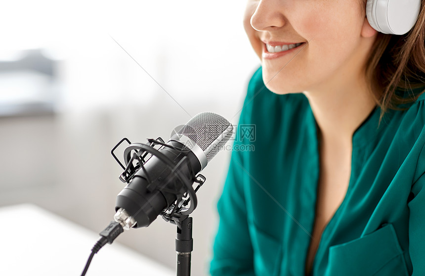 技术,大众媒体人的密切妇女与麦克风耳机交谈录音播客演播室演播室里麦克风录音播客的女人图片