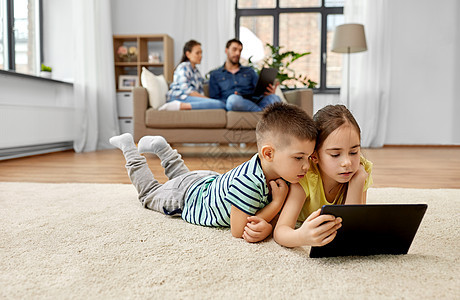 童,技术家庭观念兄弟姐妹与平板电脑躺家里的地板上哥哥妹妹家用平板电脑图片