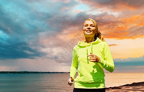 健身,运动人的快乐的女人跑海上日落的背景女人海上背景上奔跑图片