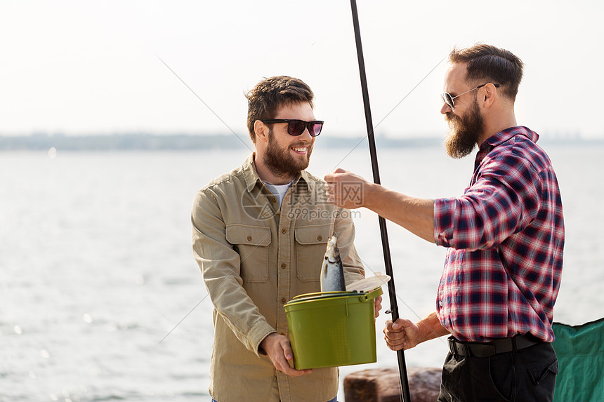 休闲人的快乐的男朋友与鱼钓鱼竿码头海上码头上鱼鱼竿的男朋友图片