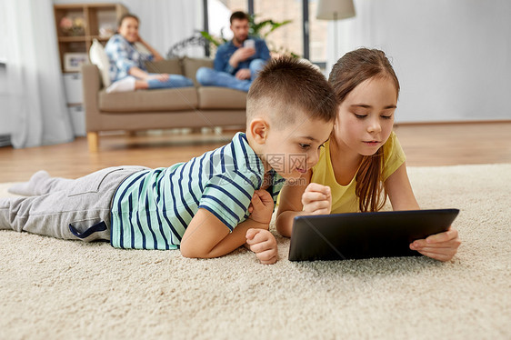 童,技术家庭观念兄弟姐妹与平板电脑躺家里的地板上哥哥妹妹家用平板电脑图片