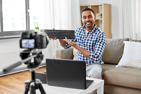 博客,视频博客人的印度男博客与相机记录视频审查电脑键盘家里男视频博客与键盘视频博客图片