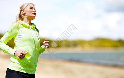 健身,运动健康的生活方式妇女与耳机运行听音乐夏季海滩背景耳机的女人公园跑图片