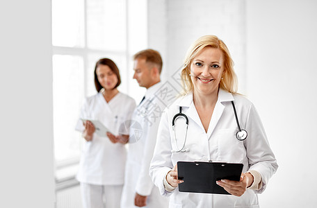 医疗保健,医学职业微笑的女中医生与剪贴板听诊器医院带剪贴板听诊器的微笑医生图片