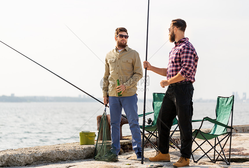 休闲人的男朋友与鱼竿啤酒码头海上码头上钓鱼竿啤酒的男朋友图片