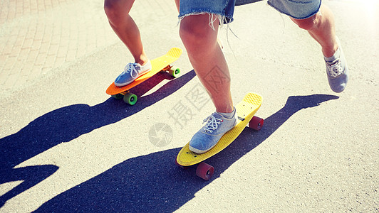 夏天,极限运动人的十几岁的夫妇骑着短的现代巡洋舰滑板城市道路上十几岁的夫妇城市道路上骑滑板图片