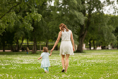 家庭童父母的母亲带着小女儿夏季公园散步妈妈带着小女儿夏天的公园散步美丽的高清图片素材