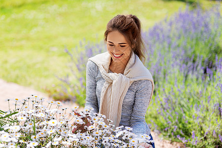 园艺人们的快乐的轻妇女与洋甘菊花夏季花园夏天花园里带花的轻女人图片