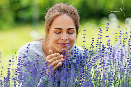 园艺人们的快乐的轻女人夏天的花园闻着薰衣草的花轻的女人花园里闻着薰衣草的花图片