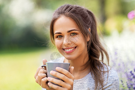 园艺人们的轻妇女夏季花园喝茶咖啡的肖像夏天花园里喝茶咖啡的女人图片