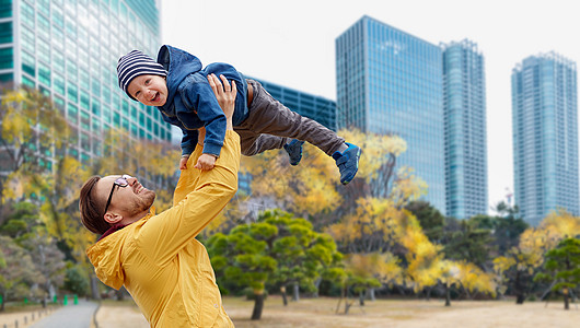 家庭,童父亲的快乐的父亲小儿子秋天的东京城市背景下玩户外玩父亲儿子秋天的东京城玩得很开心图片
