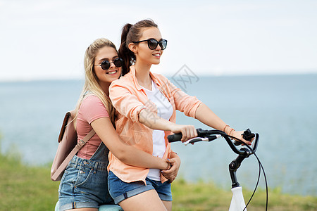 休闲友谊的快乐微笑的十几岁女孩朋友骑自行车海边夏天夏天十几岁的女孩朋友骑自行车图片