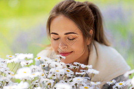 园艺人们的快乐的轻女人闻洋甘菊花夏季花园靠近闻洋甘菊花的女人图片