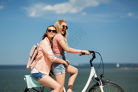 休闲友谊的快乐微笑的十几岁女孩朋友骑自行车海边夏天夏天十几岁的女孩朋友骑自行车图片