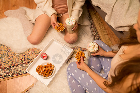 友谊,潮湿睡衣派的两个女朋友十几岁的女孩喝热巧克力与棉花糖家吃华夫饼女人喝热巧克力吃华夫饼图片