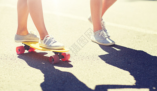 夏天,极限运动人们的青少夫妇的脚骑着短的现代巡洋舰滑板路上十几岁的夫妇路上骑滑板的脚图片