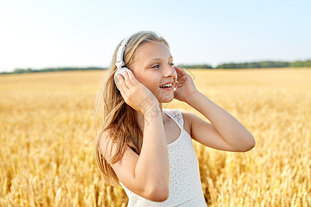 技术人的快乐女孩的肖像耳机谷物领域听音乐夏天夏天谷物地里戴耳机的快乐女孩图片