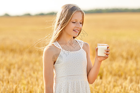 自然,健康的饮食机的微笑的轻女孩着杯牛奶谷物田夏天快乐的女孩谷物地里喝杯牛奶图片