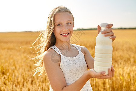 自然,健康的饮食机的微笑的轻女孩夏天的谷物地里着瓶牛奶快乐的女孩谷物地里喝瓶牛奶图片