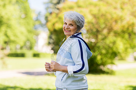 健身,运动健康的生活方式老妇女与耳机运行夏季公园戴着耳机夏天公园跑步的高级女人图片