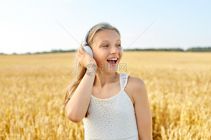 技术人的快乐女孩的肖像耳机谷物领域听音乐夏天夏天谷物地里戴耳机的快乐女孩图片