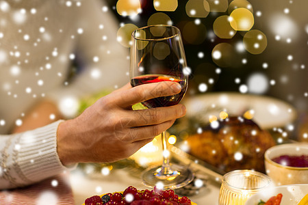 节日庆祝近距离的人吃诞晚餐喝红酒雪上诞节靠近男人喝红酒图片
