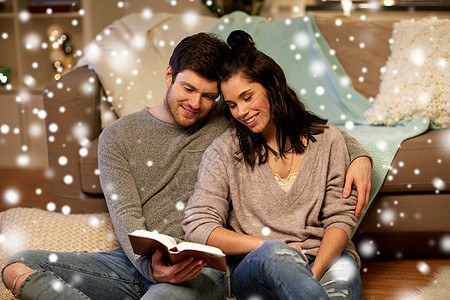 诞节,潮格人们的快乐的夫妇雪地上家看书快乐的夫妇家看书图片