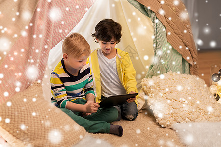 童,技术诞节的快乐的小男孩与平板电脑电脑孩子们帐篷家里的雪孩子们家帐篷里着平板电脑的小男孩背景图片